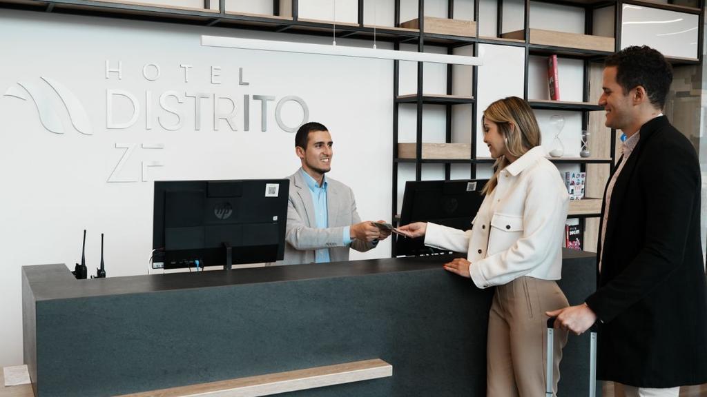 Personal del hotel entregando objeto a huésped en recepción moderna
