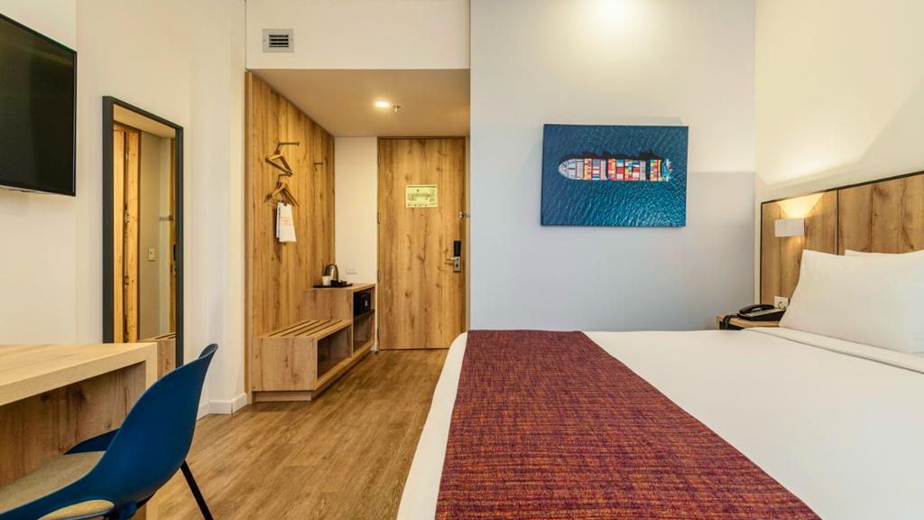Habitación moderna con cama bien presentada, decoración cálida y mobiliario funcional
