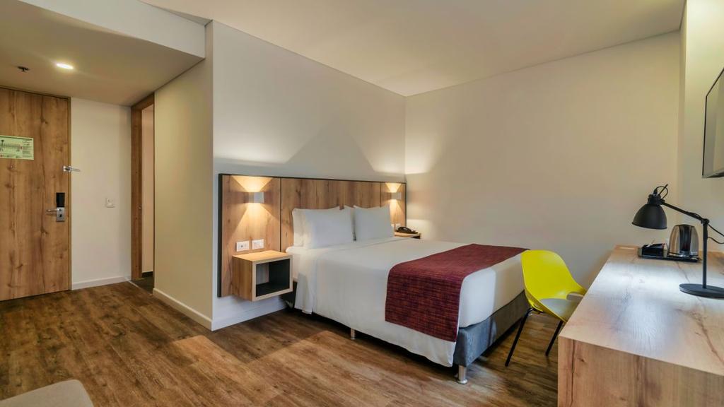 5- Habitación moderna con cama bien presentada, decoración cálida y mobiliario funcional