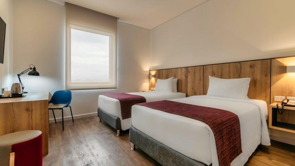5- Habitación moderna con cama bien presentada, decoración cálida y mobiliario funcional
